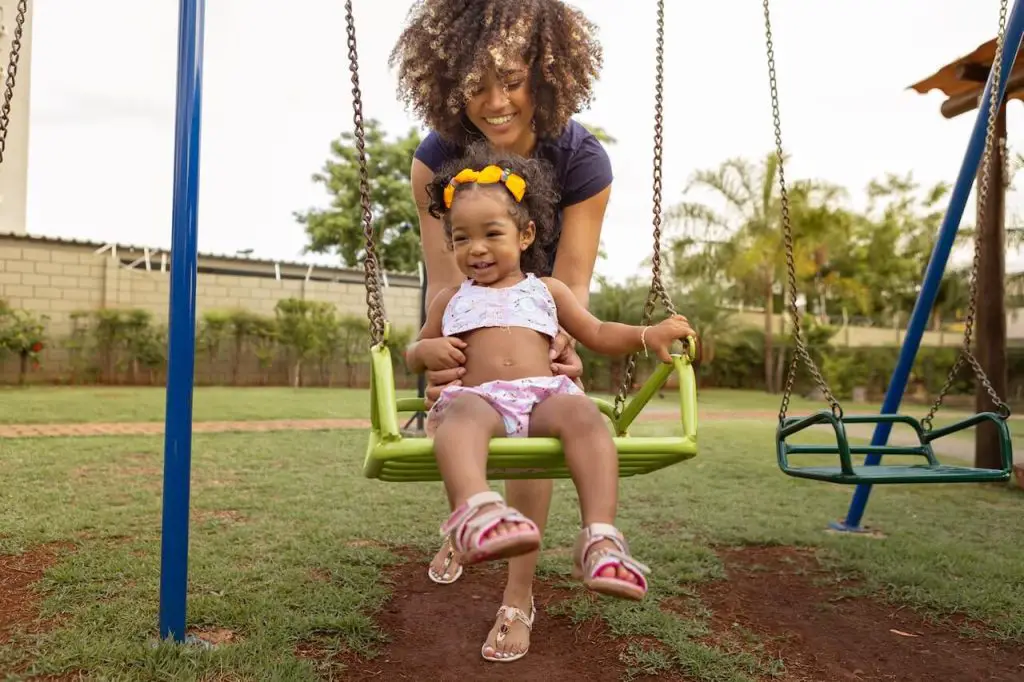 Mom Pushing Daughter on the Swings