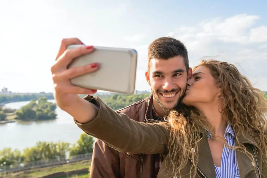 Image Of Happy Cute Young Loving Couple Posing Isolated Over Yellow  Background Take A Selfie By Mobile Phone. Stock Photo, Picture and Royalty  Free Image. Image 110978901.